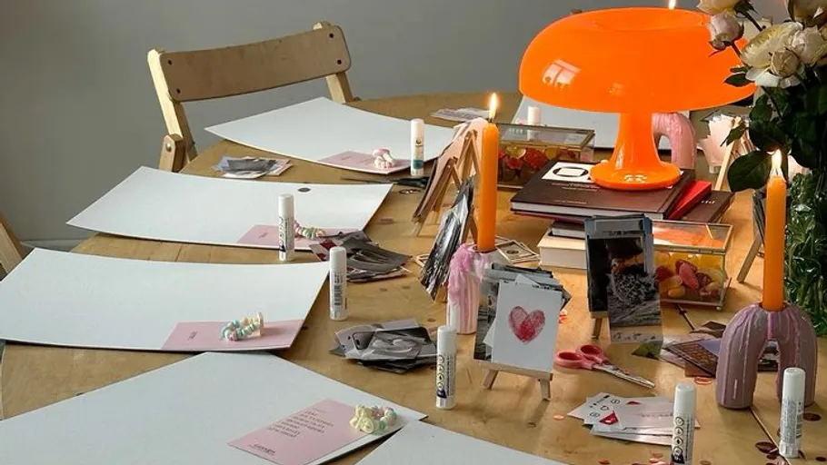 Bastelmaterialien auf einem Tisch unter Lampenlicht.