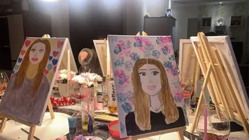 Painted portraits on easels in a room.