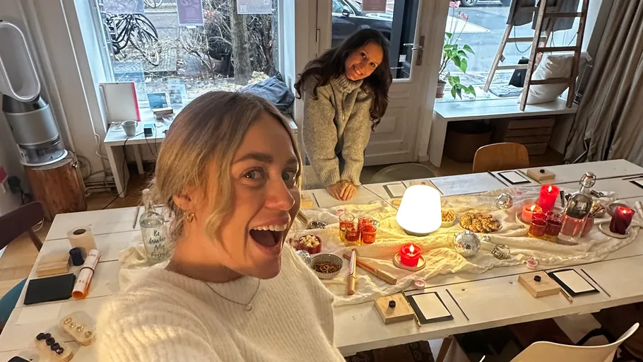 Two women smiling in decorated indoor setting.