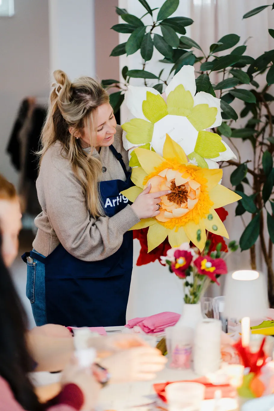 Woman creating paper flowers in a workshop.