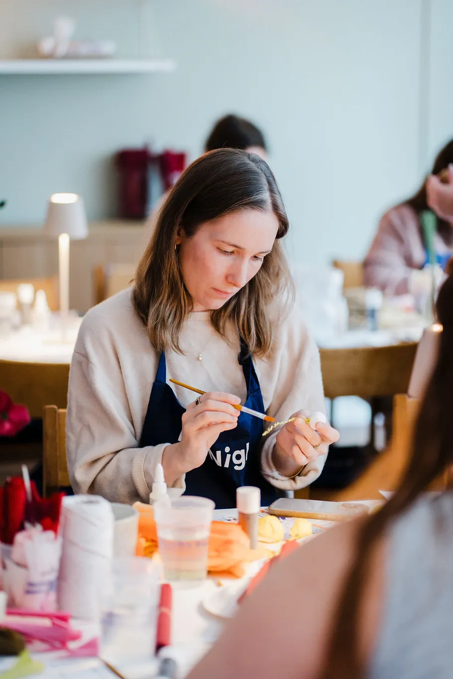 Frau malt Handwerk in einem Indoor-Workshop.
