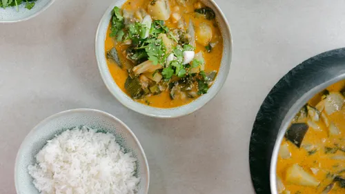 Vegetable curry and rice on a table.