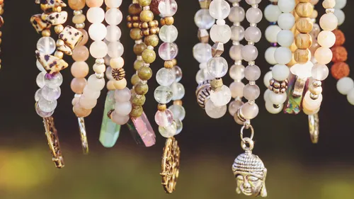 Beaded necklaces with various charms hanging closely.