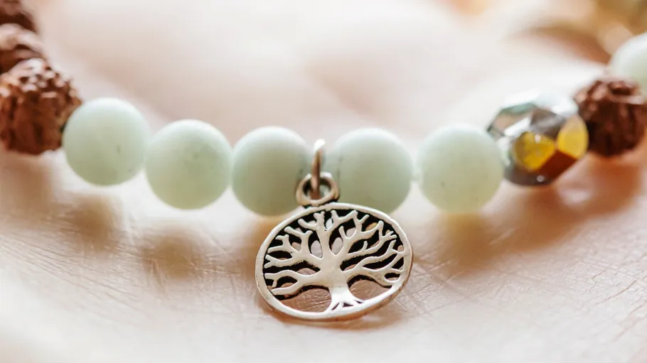 Tree charm bracelet on a hand.