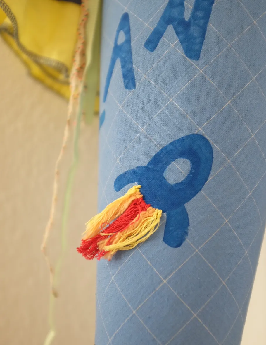 Blauer Kegel mit Raketenmotiv und Quasten.