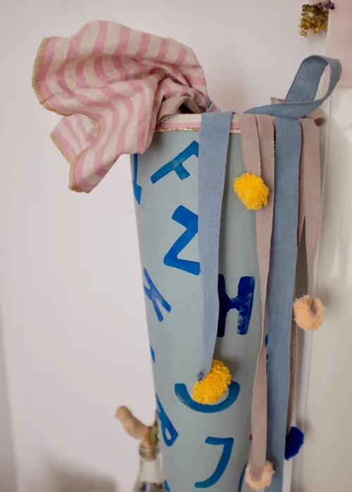 Decorative fabric cone with ribbons on wall.