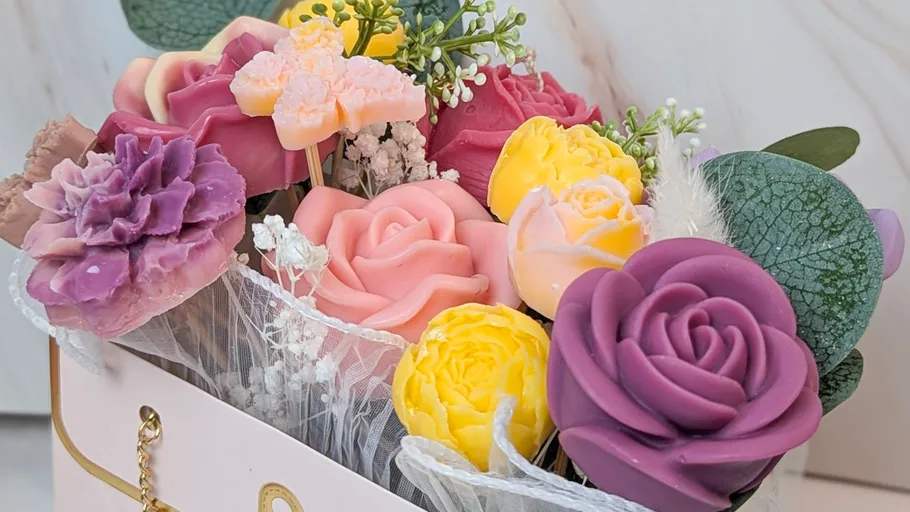 Bunte Seifenblumen in einer rosa Box.