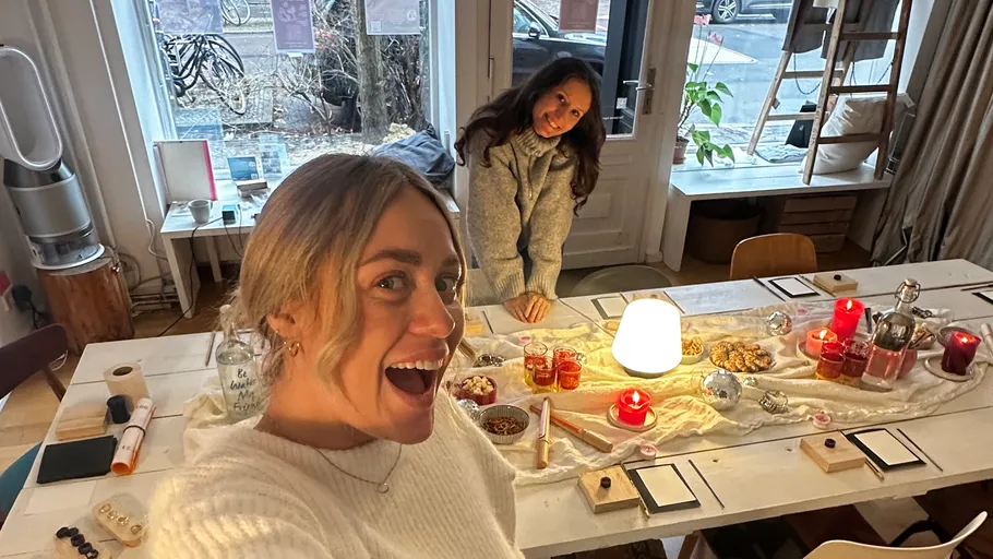 Two women smiling in decorated room.