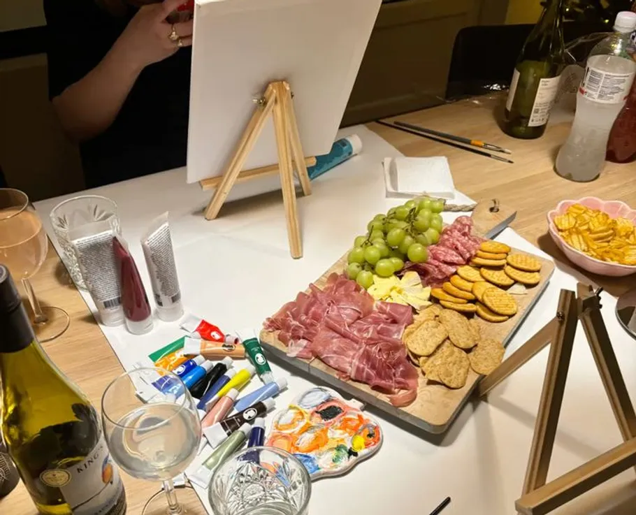 Tisch mit Farben, Snacks und Leinwandsystem.