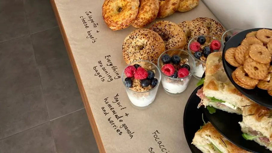 Breakfast spread with bagels, yogurt, and sandwiches.