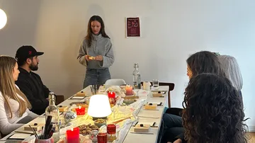 Personen an einem Tisch mit Kerzen.