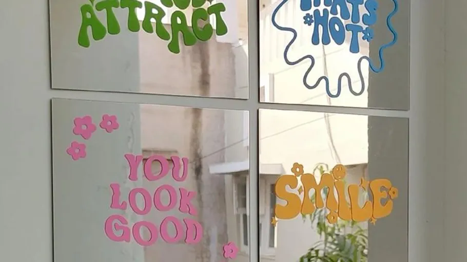 Colorful decals with positive phrases on mirror.