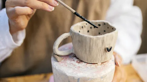 Hand bemalt Keramiktasse mit schwarzen Punkten.