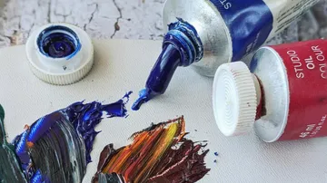 Oil paint tubes spilling colors on palette.