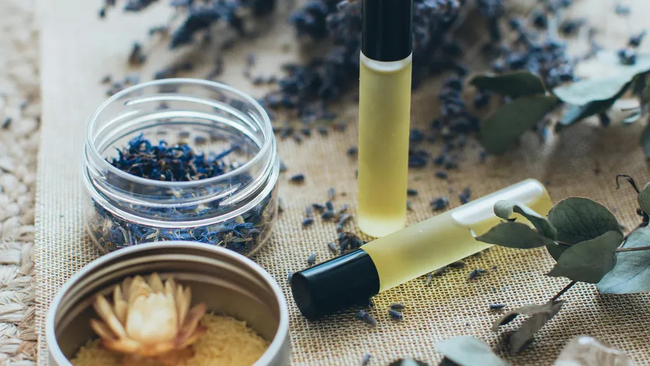 Essential oils with dried flowers, natural setting.