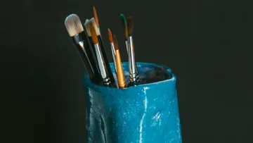 Pinsel stehen in einem blauen Halter.