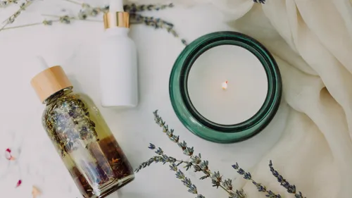 Essential oils and candle with lavender sprigs.
