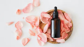 Bottle with dropper on rose petals.