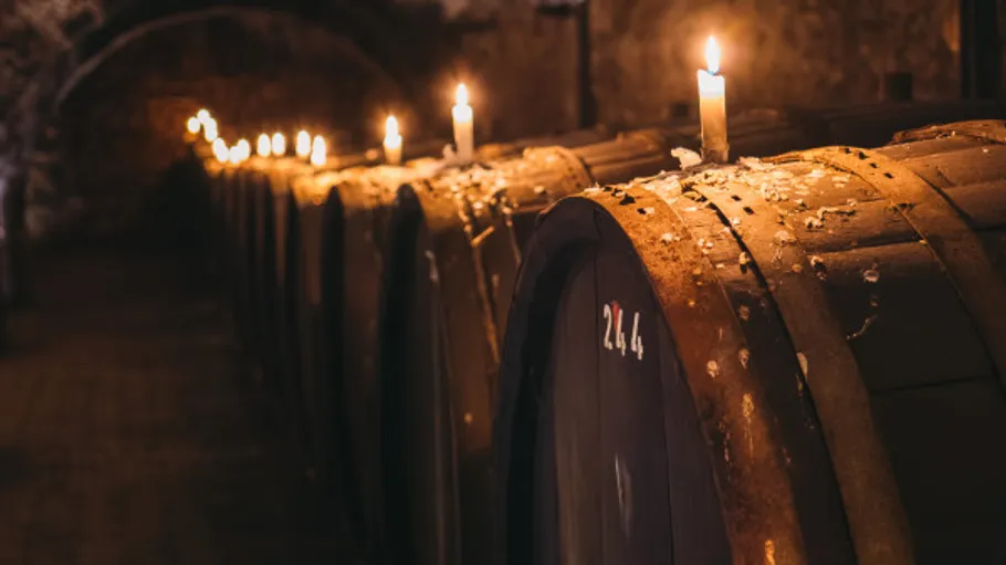 Wine barrels in a candlelit cellar.