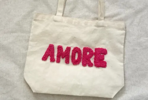 Stofftasche mit pinkem 'AMORE' Schriftzug.