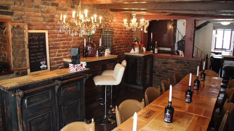 Cozy bar with brick walls and chandelier lighting.