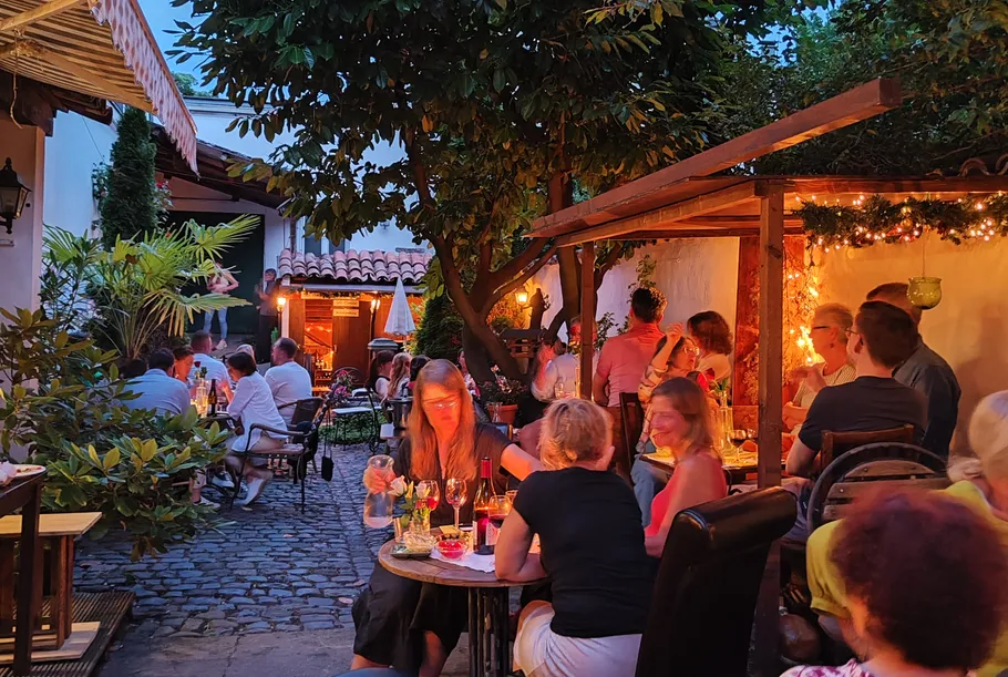 Menschen essen in einem gemütlichen Außenbereich.