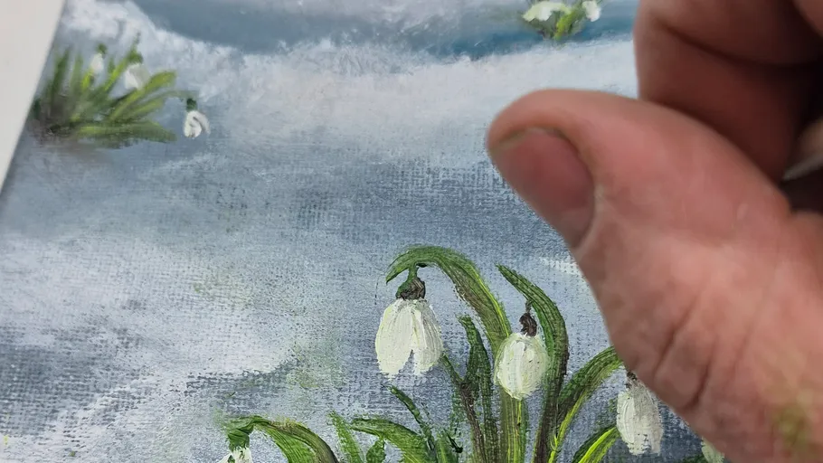 Hand malt Schneeglöckchen in schneelandschaft.