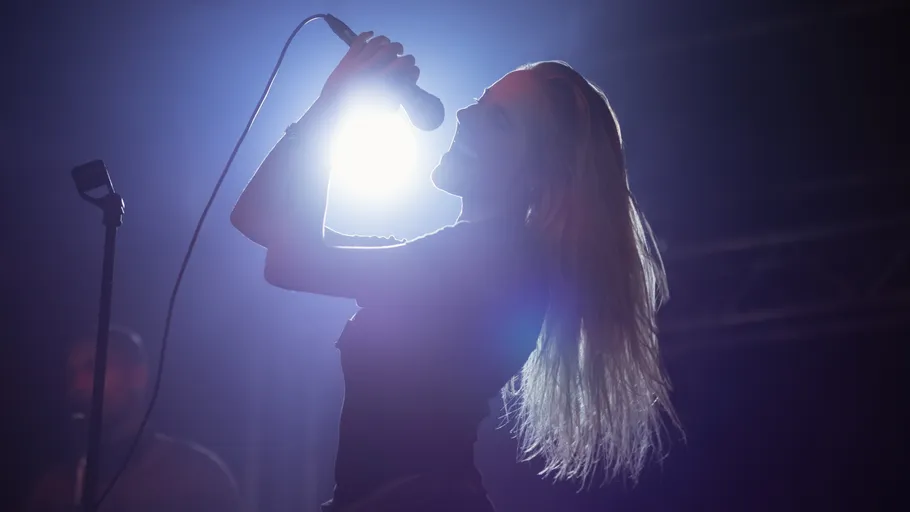 Singer performing on stage with microphone.