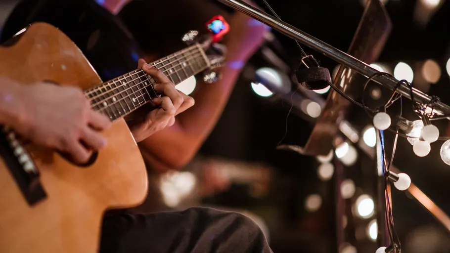Person playing guitar at live music event.
