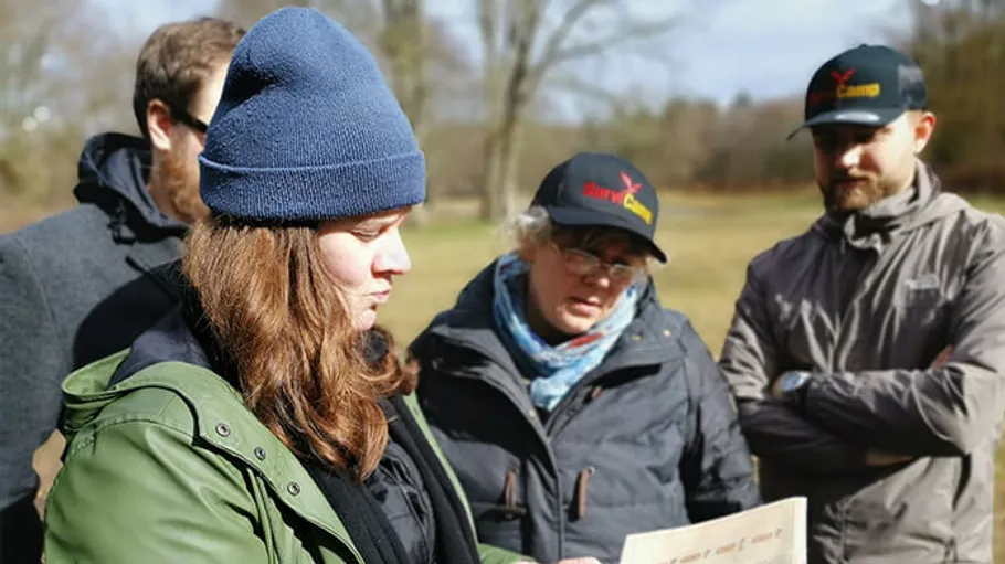 Group of people reading a map outdoors.