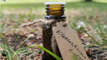 Kleine Flasche mit Etikett auf Gras.