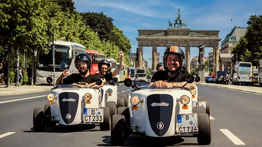 Menschen fahren Miniautos in der Nähe vom Brandenburger Tor.