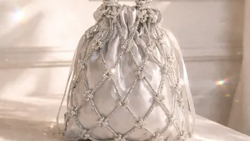 Elegante Perlen-Taschenkette auf Tisch.