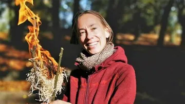 Person hält brennende Zweige im Freien.
