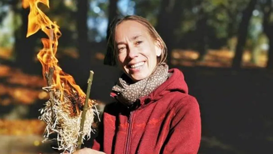 Person hält brennende Zweige im Freien.