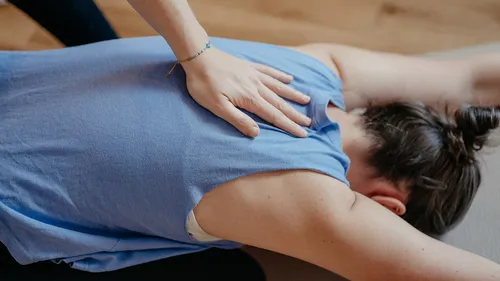 Person in blue shirt receiving back massage.