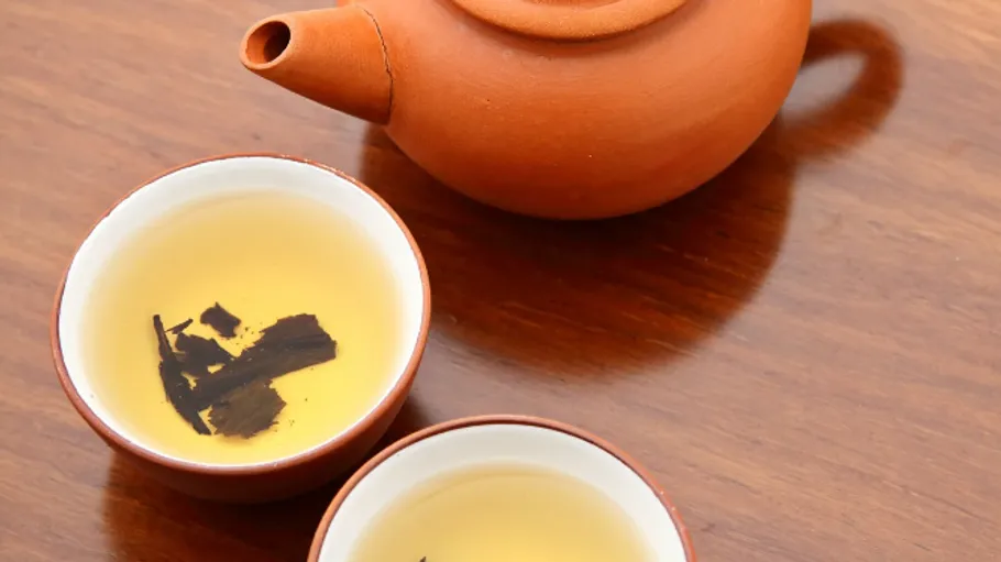 Zwei Teetassen und Teekanne auf Tisch.