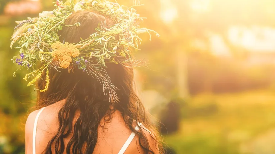 Woman with floral crown in sunlight outdoors.