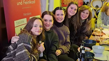 Fünf Frauen sitzen zusammen an einem Tisch.