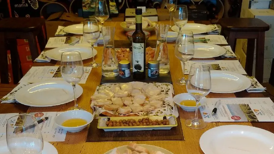 Table set with dishes, wine, and olives.