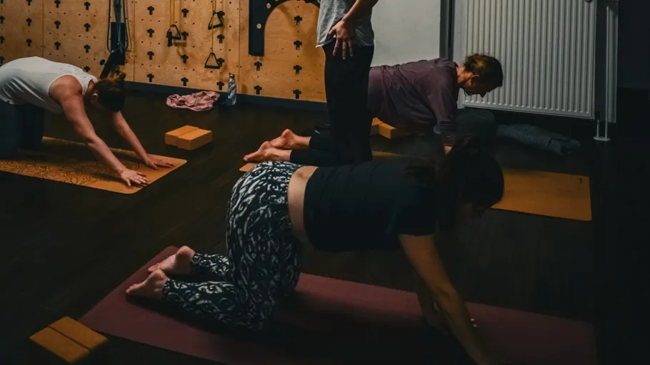 Vier Personen praktizieren Yoga im Studio.