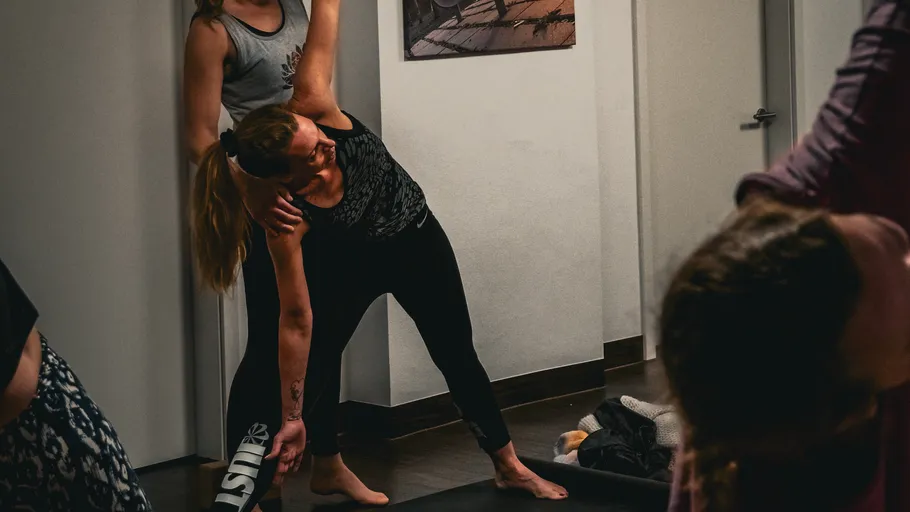 Zwei Frauen üben Yoga drinnen.