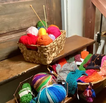 Colorful yarn balls and knitted items on stairs.
