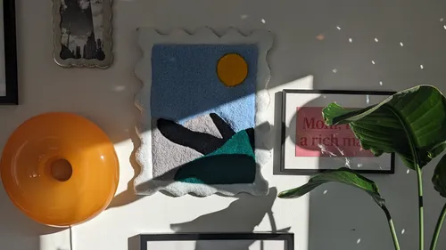 Wandkunst und Pflanze im Sonnenlicht.