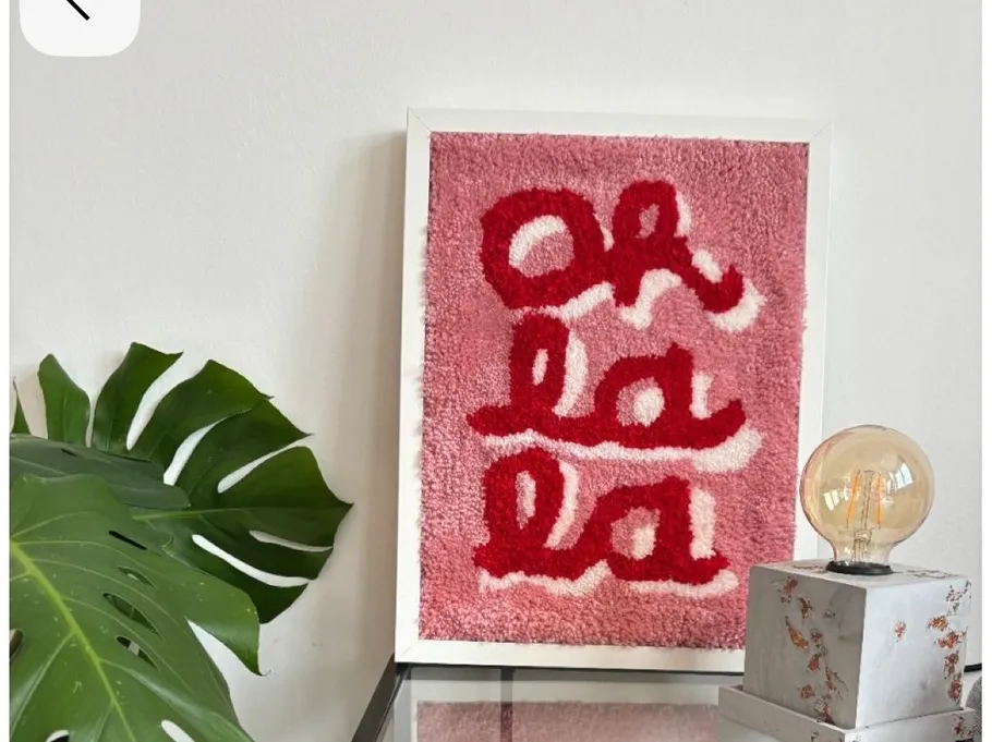 Framed pink rug art says 'Oh la la'.