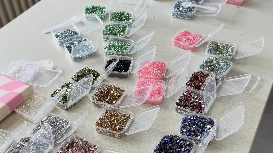 Bunte Glitzerbehälter auf Tisch angeordnet.