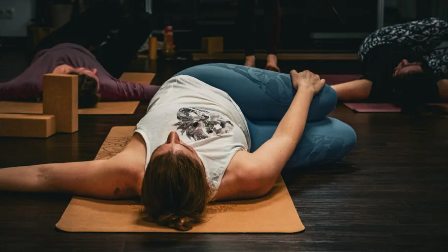 Person practicing yoga on mat in studio.
