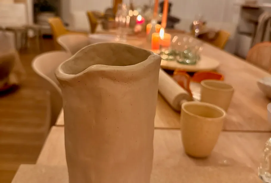 Clay pitcher on a wooden dining table.