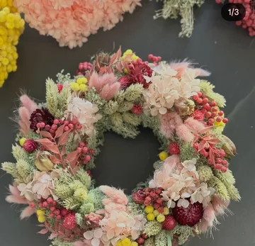 Bunter Blumenkranz auf dunkler Oberfläche.