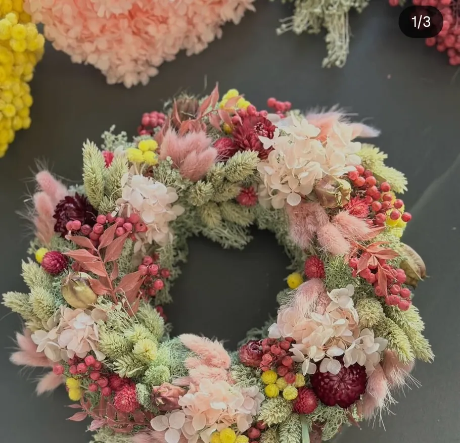 Colorful floral wreath on dark surface.